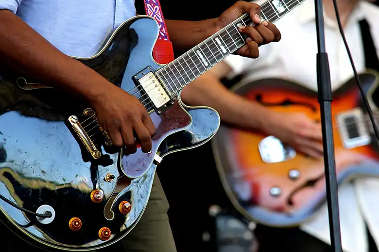 Dos hombres tocando guitarras eléctricas en el escenario