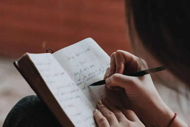 Chica escribiendo letras en una libreta