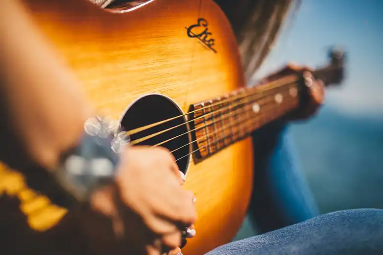 Persona tocando guitarra acústica