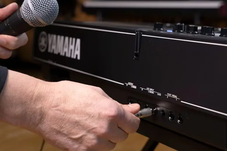 Persona conectando micrófono en Yamaha CK88