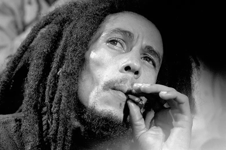 La imagen muestra a Bob Marley fumando un cigarro