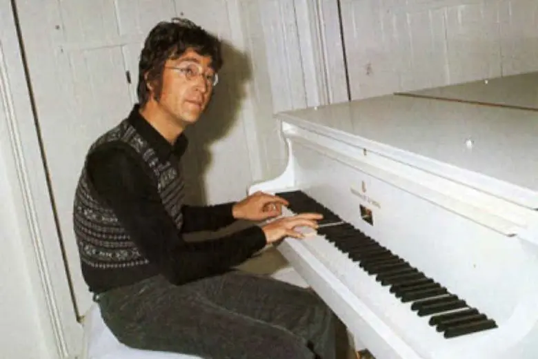 John Lennon tocando su piano blanco