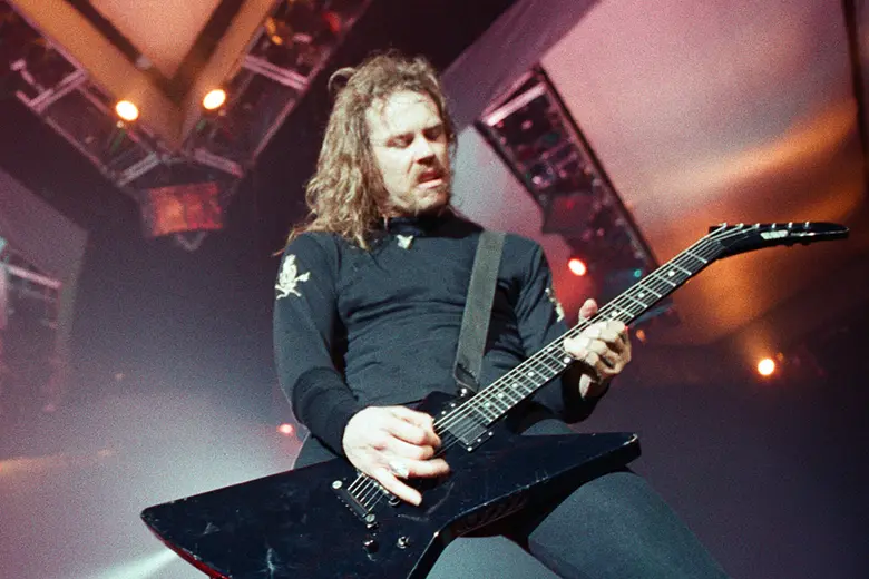 La foto muestra a James Hetfield tocando la guitarra en el escenario en 1992