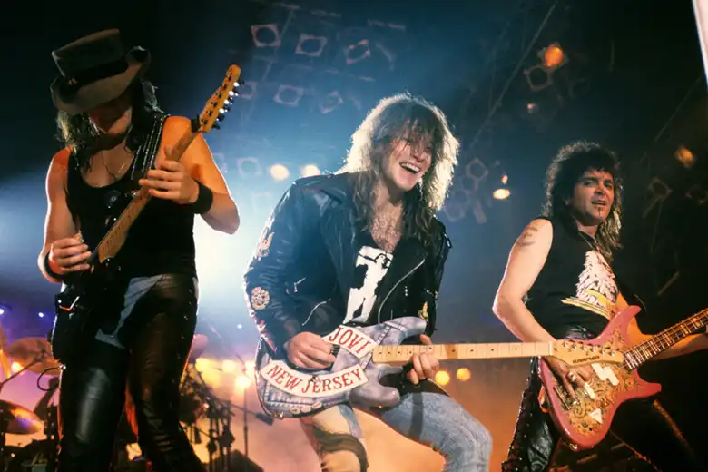 La imagen muestra a la banda Bon Jovi sobre el escenario en los años 80.