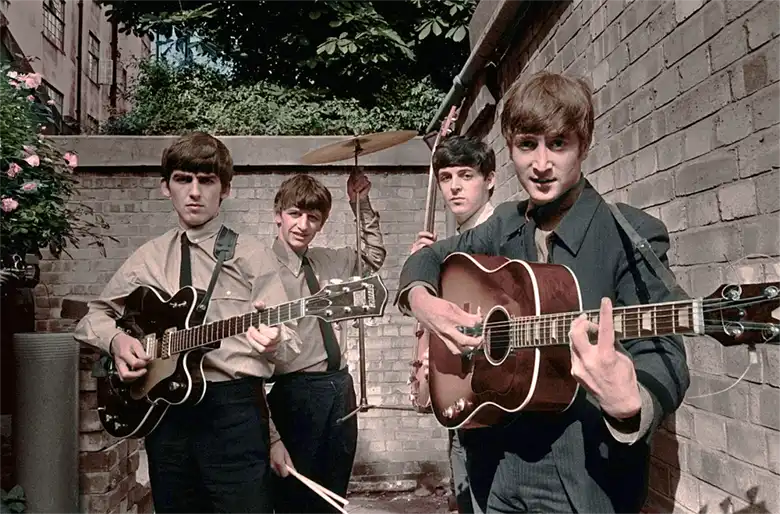 La imagen muestra a unos muy jóvenes Beatles tocando en el patio de una casa.