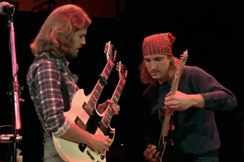 La imagen muestra a Don Felder y Joe Walsh tocando "Hotel California" sobre el escenario en los 70.