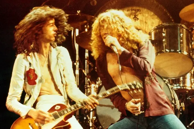 La imagen muestra a Jimmy Page y Robert Plant de Led Zeppelin actuando en un escenario.