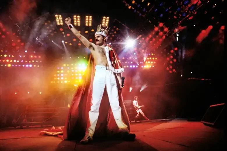 Es una imagen que muestra a Freddie Mercury sobre el escenario con una corona sobre su cabeza.